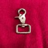 1trigger6 Metal clip on red fabric background.
