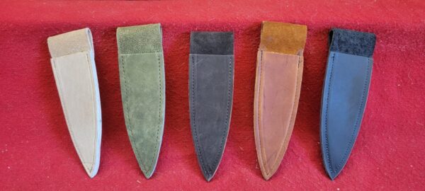 Five leather knife sheaths on red fabric.