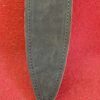 Black leather sheath on red fabric background.
