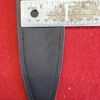 Black leather sheath with measuring tape on red.