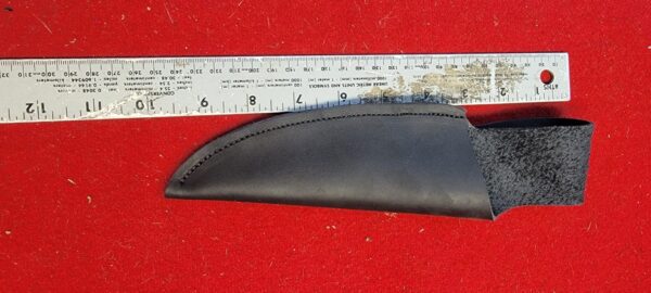 Black knife sheath next to measuring ruler.