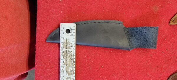 Leather knife sheath next to measuring ruler.