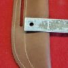 Leather knife sheath with a measuring tape.