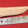 20230420_164749 Leather knife sheath beside metal ruler.