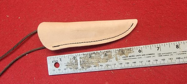 20230420_164749 Leather knife sheath beside metal ruler.
