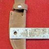 20230420_175702 Leather knife sheath with ruler on red.