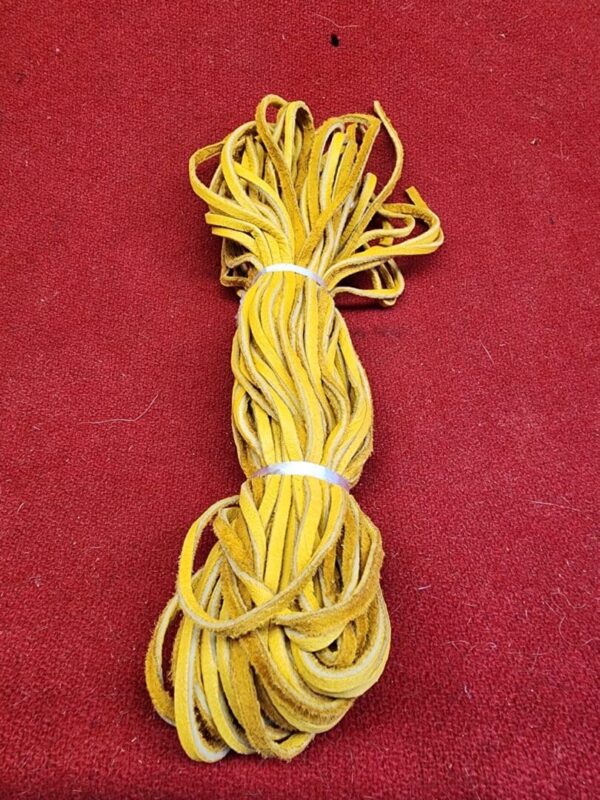 20240106_135543 Yellow leather laces on red background.