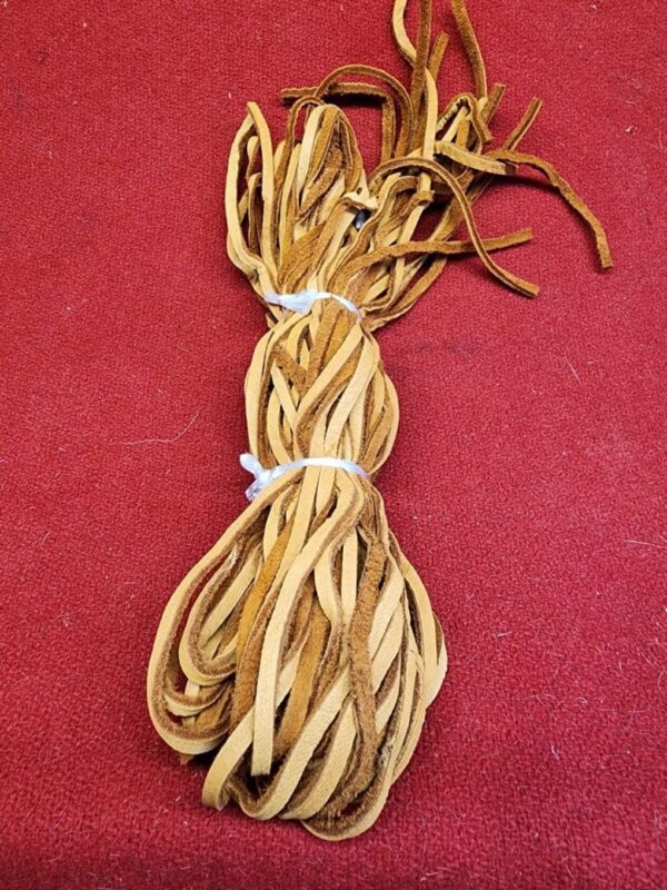 20240106_135549 Brown leather strips on red background.