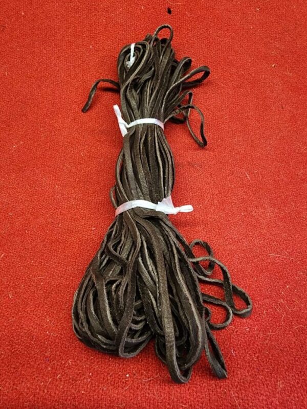 20240106_135614 Bundle of brown leather laces on red.