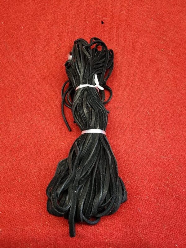 20240106_135622 Bundle of black cords on red background.