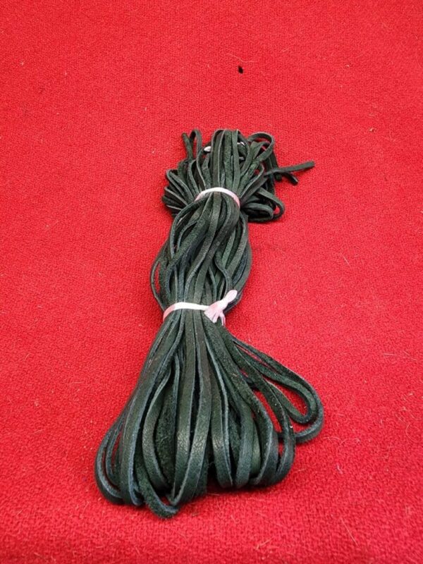 20240106_135643 Bundle of black shoelaces on red background.