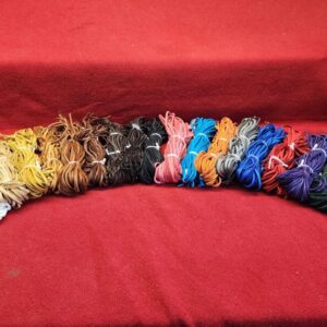 20240106_141316 Colorful shoelaces arranged on red fabric.