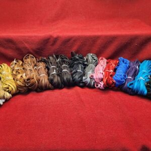 20240106_145251 Colorful bundles of fabric on red background.