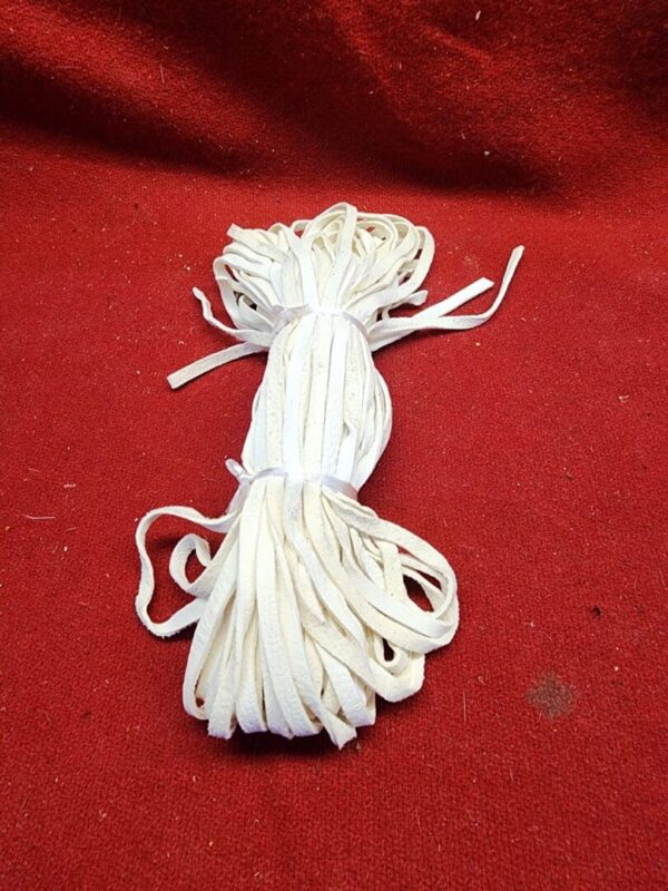 Bundle of white shoelaces on red background.