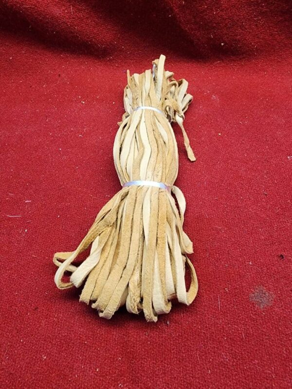 Bundle of leather strips on red background.