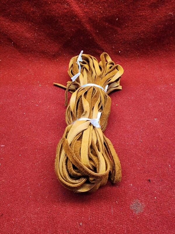 Brown leather laces on red background.