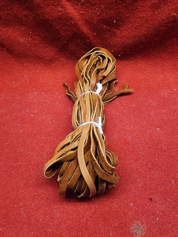 Bundle of brown leather strips on fabric.