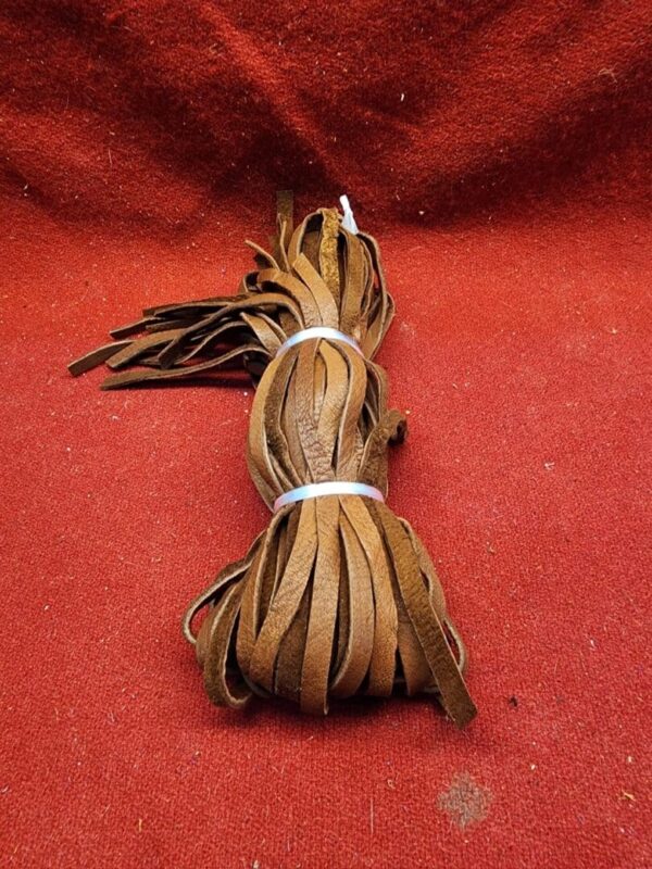 Brown leather strips on red fabric background.