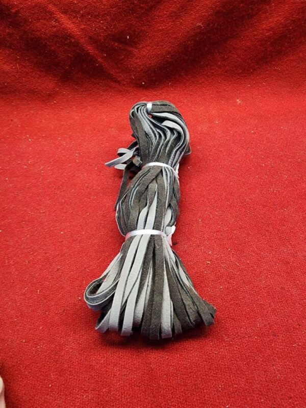 Stack of leather strips on red fabric.