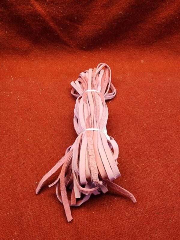 Bundle of pink leather strips on fabric.