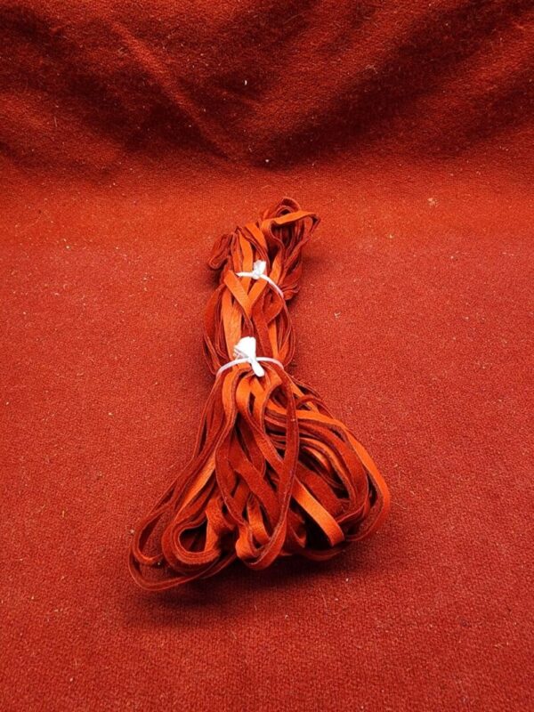Red shoelaces bundled on red fabric.