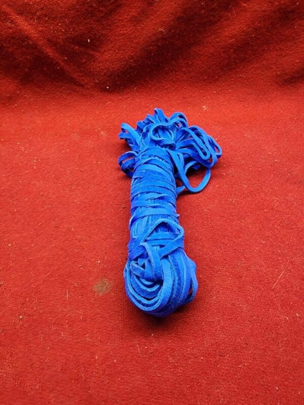 Blue shoelace on a red surface.