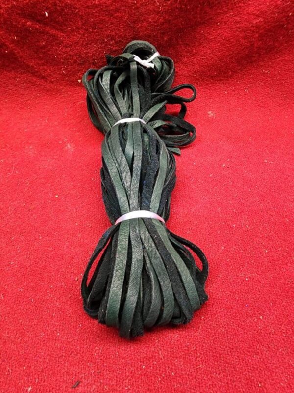 Bundle of black leather strips on red.