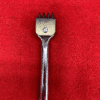 Metal tool on a red surface.