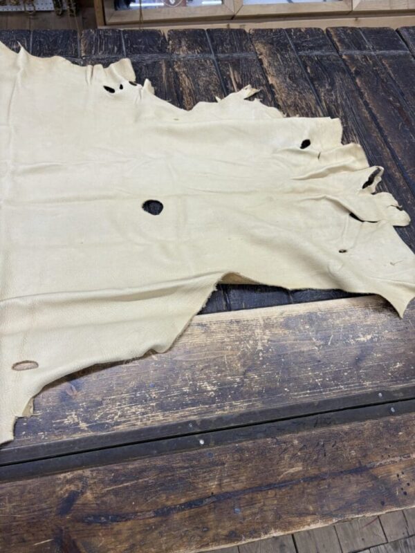 IMG_2886 Tan leather hide on a wooden table.