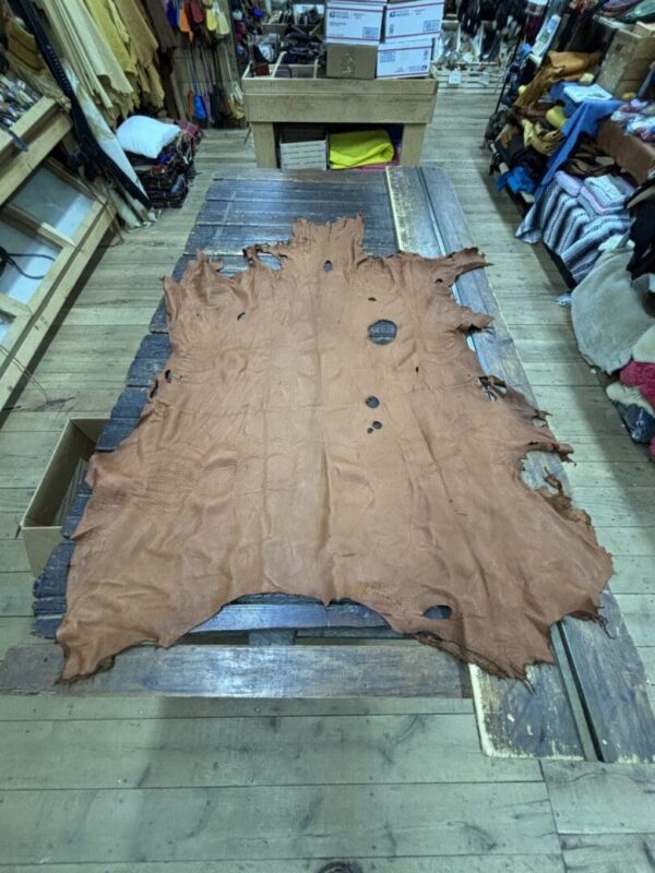 Large brown leather hide on wood table.