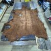Brown leather hide on a wooden table.