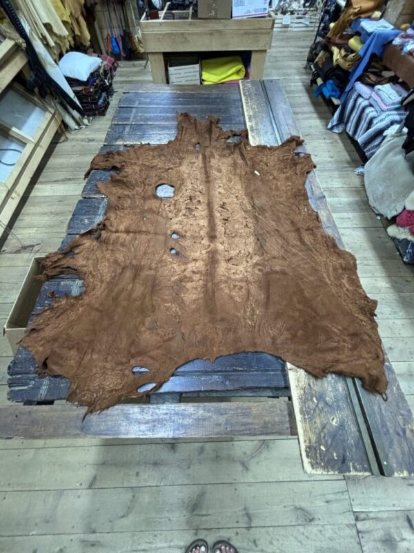 Brown leather hide on a wooden table.