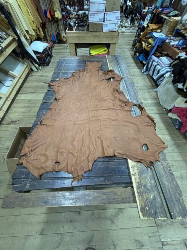 Large brown leather hide on table.