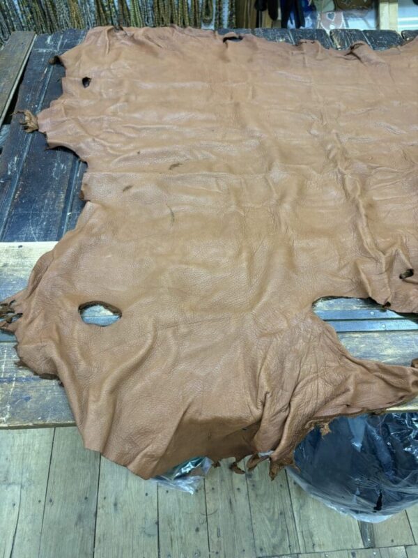 Brown leather hide on a wooden surface.
