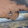 Brown leather hide on wooden table.
