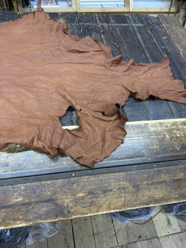 Brown leather hide on wooden table.