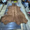 Brown leather hide on wooden table.