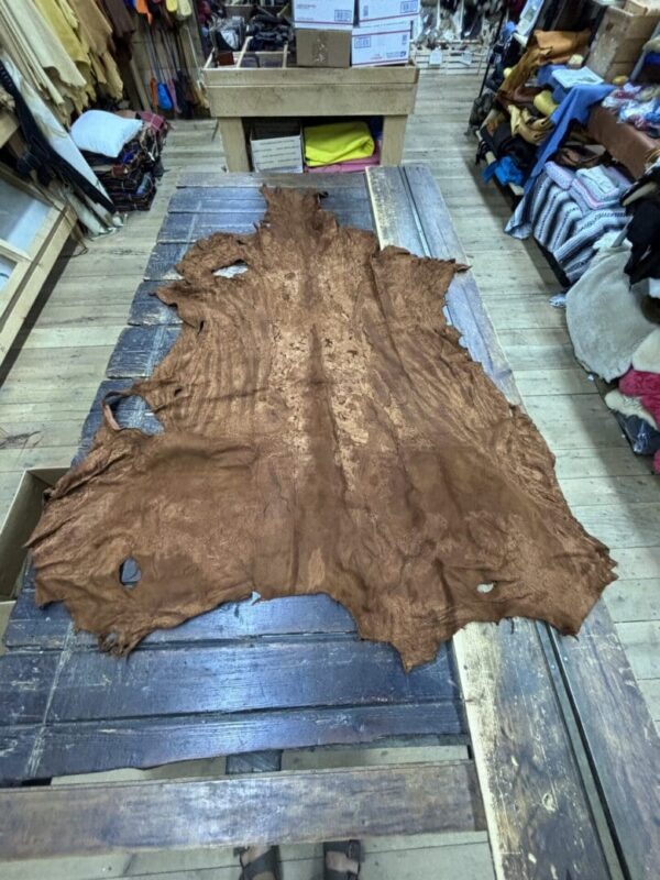 Brown leather hide on wooden table.