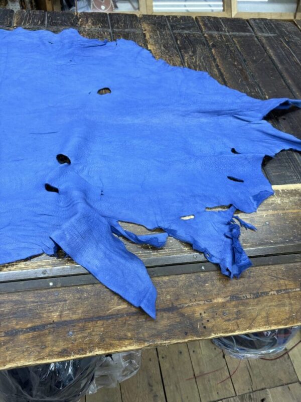 Blue leather scrap on wood table.