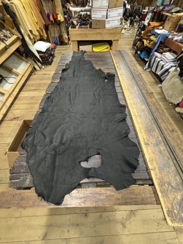 Black leather hide on wooden table.