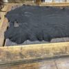 Black leather hide on wooden table.