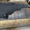 Black leather hide on wooden table.