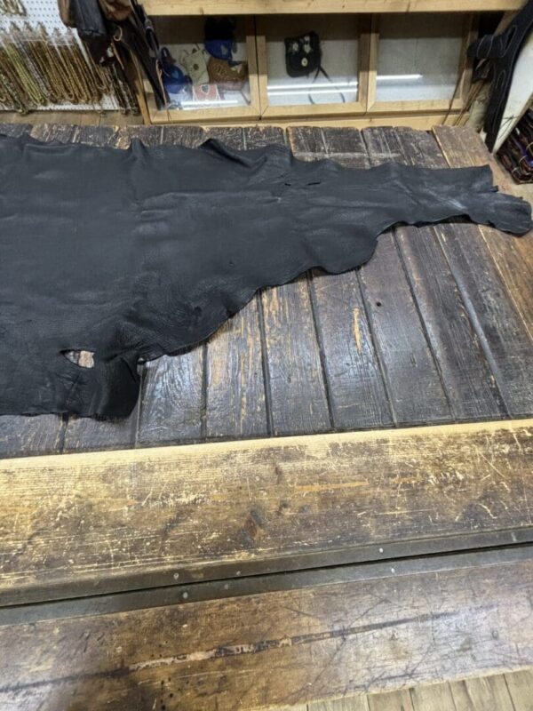 Black leather hide on wooden table.