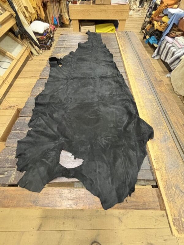 Black leather hide on wooden table.