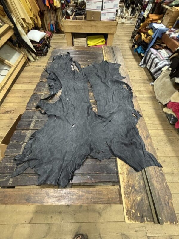 IMG_2909 - Copy Two pieces of black leather on wood.