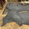 IMG_2910 Black leather hide on wooden surface.