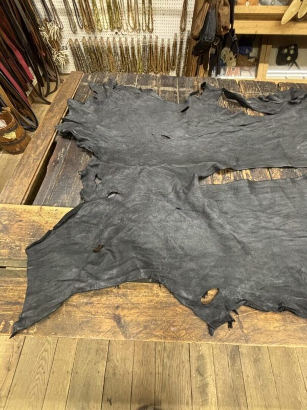 IMG_2910 Black leather hide on wooden surface.