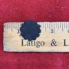 Black flower shape on wooden ruler.