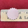 Pink scalloped circle on a ruler.