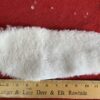 White wool pad on red surface, ruler below.